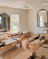 Pilates reformers in a studio with large mirrors and a window.